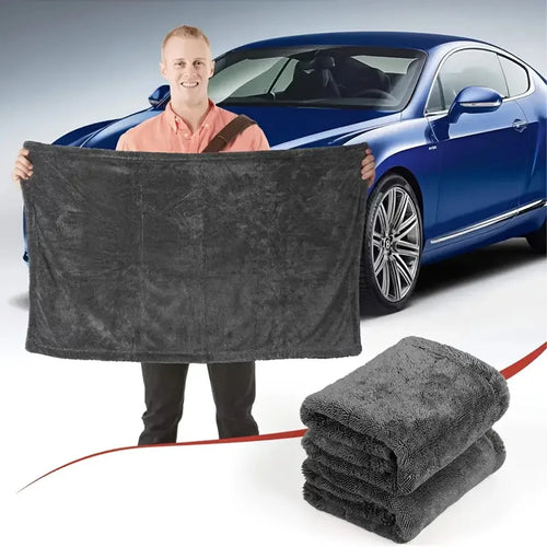 Ręcznik 90×60 cm trzymany w dłoniach na tle samochodu — skala